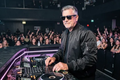 DJ professionnel derrière une table de mixage dans un grand club de nuit, ambiance électro avec foule en arrière-plan